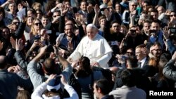 Pope Francis leaves at the end of a special audience with engaged couple, to celebrate Saint Valentine's day, in Saint Peter's square at the Vatican, Feb. 14, 2014.