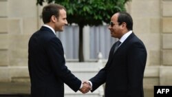 Presiden Perancis, Emmanuel Macron (kiri) menjabat tangan Presiden Mesir, Abdel Fattah el-Sisi saat tiba di Istana Elysee di Paris, 24 Oktober 2017.