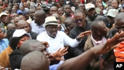 Kenya's opposition leader, Raila Odinga, centre, joins his supporters in the Mathare area where four people were killed overnight, in Nairobi, Nov. 19, 2017. 