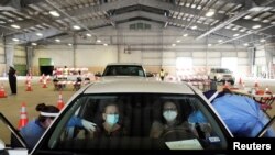 Eva Martinez and Sandra Vaden receive COVID-19 vaccines at a drive-through site in Robstown, Texas, Feb. 9, 2021.