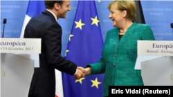 En la imagen, el presidente francés Emmanuel Macron y la canciller alemana Angela Merkel se dan la mano tras una rueda de prensa conjunta después de la cumbre de la UE en Bruselas, Bélgica, celebrada el 15 de diciembre de 2017. 