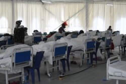 FILE - Patients rest on their beds at the Kenyatta stadium where screening booths and an isolation field hospital are installed to aid with COVID-19 treatment in Machakos, Kenya, July 28, 2020.
