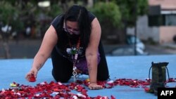 Una mujer deja pétalos de flores como recuerdo a la migrante salvadoreña Victoria Salazar en San Salvador, El Salvador, el 30 de marzo de 2021.