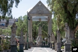 Sculptures made by the stone carvers of Chimalhuacan adorn the entrance of the cemetery in the Mexico City borough of Chilmalhuacan, once the ancient village of Xochiaca, Sunday, July 2, 2023. (AP Photo/Aurea Del Rosario)