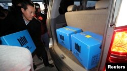 A prosecution investigation officer moves boxes carrying evidence seized at a branch office of National Pension Service in Jeonju, South Korea, Nov. 23, 2016.