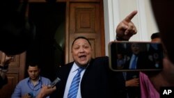 FILE - Lawmaker Jose Brito tells the press he supports fellow lawmaker Luis Parra as the legislature's president, after Parra's press conference at the National Assembly in Caracas, Venezuela, Jan. 6, 2020. 