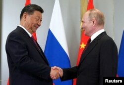 Presiden Rusia Vladimir Putin berjabat tangan dengan Presiden China Xi Jinping selama pertemuan di sela-sela KTT Organisasi Kerja Sama Shanghai (SCO) di Astana, Kazakhstan, 3 Juli 2024. (Foto: Sputnik/Pavel Volkov/Pool via REUTERS)