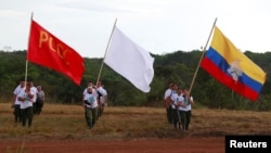 Fighters from Revolutionary Armed Forces of Colombia walk at the camp before the closing ceremony of a rebel congress near El Diamante in Yari Plains, Colombia, Sept. 23, 2016.