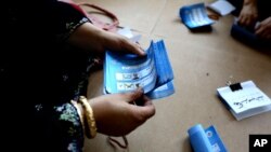 An Afghan election worker counts ballots at a polling station in Jalalabad, east of Kabul, Afghanistan, June 14, 2014. 