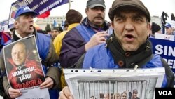 Para demonstran anti-pemerintah di Bucharest membawa poster para pemimpin Rumania "yang dipenjarakan" dengan berbagai slogan: "Mereka harus diadili atas apa yang telah mereka curi (dari rakyat)."