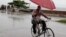 A man balances a child and umbrella on his bike as it rains during the approach of Hurricane Sandy in Manzanillo, Cuba, Oct. 24, 2012. 
