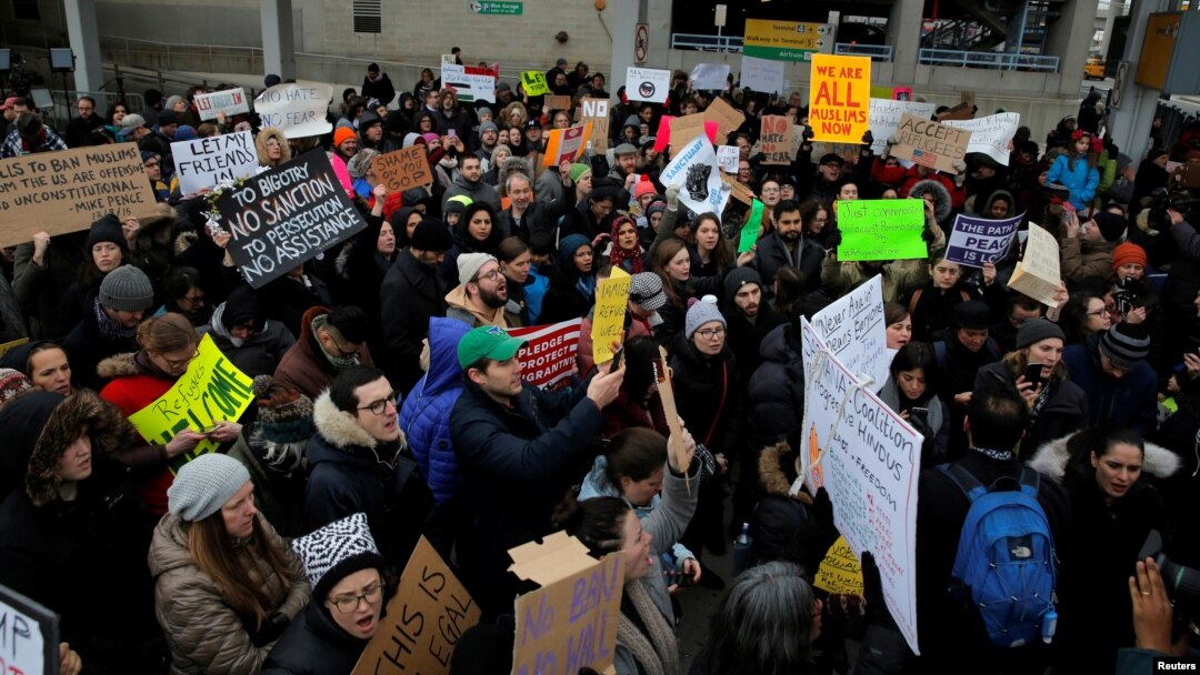 Protes menentang larangan imigrasi Donald Trump di luar Terminal 4 di Bandar Udara John F. Kennedy di Queens, New York (28/1). (Reuters/Andrew Kelly)