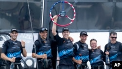 In this photo provided by SailGP, Peter Burling, Co-CEO and driver of New Zealand SailGP Team, lifts the trophy as the team celebrates aboard their F50 catamaran after winning the Mubadala New York Sail Grand Prix in New York, June 23, 2024.
