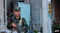 This photo taken on November 9, 2023 shows a fighter of the ethnic armed group Ta'ang National Liberation Army (TNLA) standing guard in the town of Namhkam in northern Shan state.