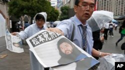 Seorang karyawan harian Mainichi Shimbun membagikan edisi ekstra dengan berita utama eksekusi pemimpin sekte hari kiamat, Shoko Asahara, di Tokyo, 6 Juli 2018. Asahara dan enam pengikutnya dieksekusi mati pada Jumat pekan lalu karena melancarkan serangan gas sari mematikan pada 1995 di stasiun kereta bawah tanah di Tokyo dan kejahatan lainnya.
