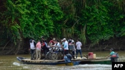 Personas desplazadas por recientes enfrentamientos entre grupos armados cruzan el río Tarra, que divide a Colombia y Venezuela, para llegar a Tres Bocas, estado Zulia, Venezuela, el 19 de enero de 2025. AFP