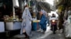 Afghan burqa-clad women walk through a market in Kandahar, Aug. 24, 2024. 