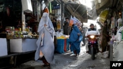 Sejumlah perempuan yang mengenakan burka berjalan di sebuah pasar di Kandahar, Afghanistan, pada 24 Agustus 2024. (Foto: AFP/Wakil Kohsar)