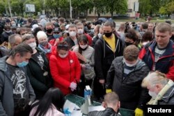 FILE - Supporters of Svetlana Tikhanovskaya collect signatures in support of her nomination as a candidate in the upcoming presidential election, in Minsk, Belarus, May 24, 2020.