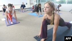 Women holding a pose during a yoga class.