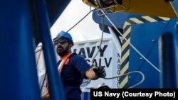 Steven Benjamin, a contractor with Phoenix International Incorporated, rigs a guideline through the tow pinger locater 25 (TPL 25) aboard USNS Apache (T-ATF 172). USNS Apache departed Norfolk, Virginia, on Oct. 19 to begin searching for wreckage from the 