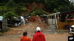 Civil Defense workers look the area where a couple was killed after their home was destroyed by a mudslide in Arraijan on the outskirts of Panama City, Tuesday, Nov. 22, 2016. Civil defense officials in Panama say the country has already seen three deaths blamed on late-season Tropical Storm Otto.