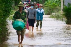 Locals walking through a flooded road in Quang Tri.