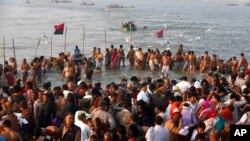 Indian Hindu devotees gather to take holy dips at Sangam, the confluence of the Rivers Ganges, Yamuna and mythical Saraswati on Maghi Purnima, or the full-moon day of the month during the annual "Magh Mela" fair in Allahabad, Feb. 10, 2017.