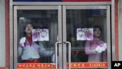 중국 단둥의 북한 식당에서 유리를 닦는 북한인 종업원들. (자료사진)