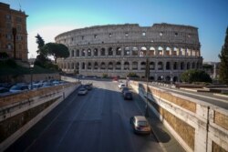 An empty street leads to the ancient Colosseum, in Rome, March 24, 2020.