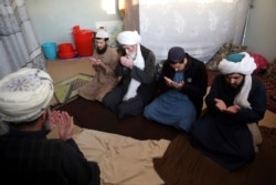 FILE- Jailed Taliban pray inside the Pul-e-Charkhi prison after an interview with The Associated Press in Kabul, Afghanistan, Dec. 14, 2019.