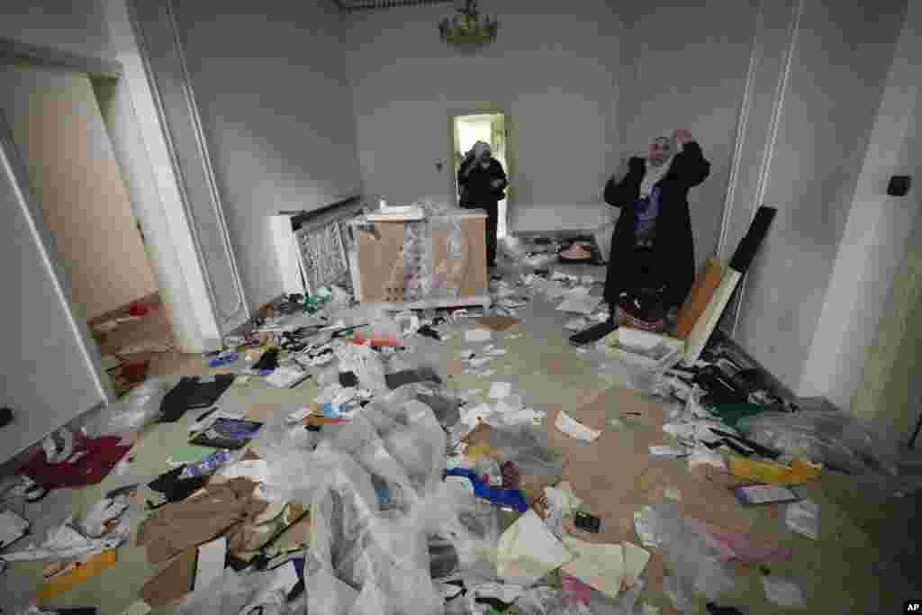 A woman looks at a ransacked room at the private residence of Syrian President Bashar Assad in the Malkeh district of Damascus, Dec. 8, 2024.