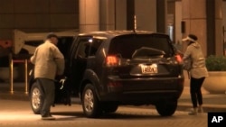 In image made from a video, China Innovation Investment Ltd. officials Xiang Xin and his wife Kung Ching get off a car at the Grand Hyatt hotel in Taipei, Taiwan, Nov. 25, 2019.