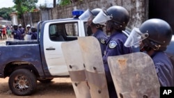 Des policiers dispersent la foule autour d'un corps suspecté d'être atteint du virus d'Ebola le 14 août 2014. 