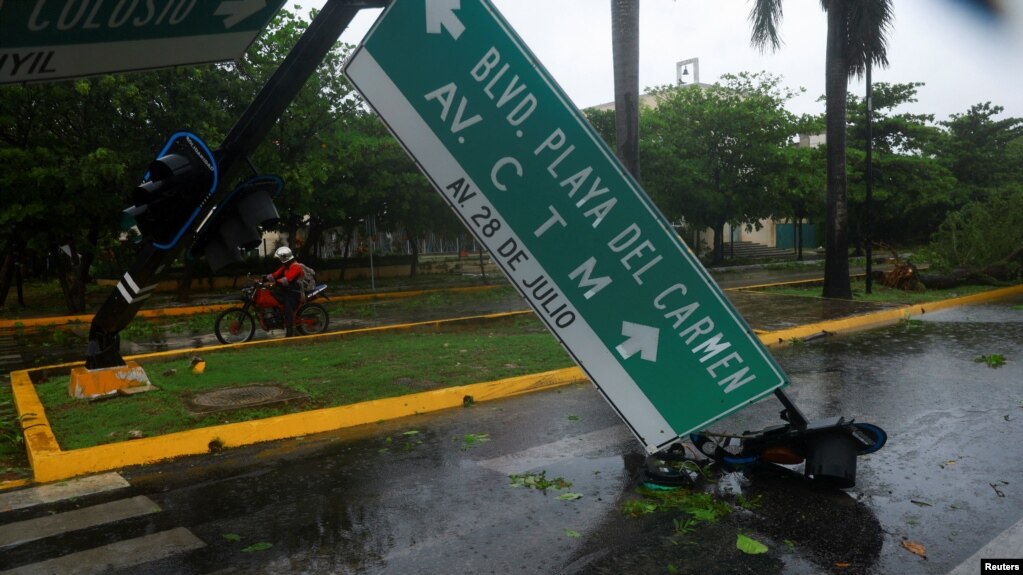 Un automovilista pasa por un semáforo derribado por fuertes vientos y lluvias causados ​​por el huracán Beryl, una tormenta de categoría 2, en Playa del Carmen, México, el 5 de julio de 2024.