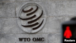 A logo is pictured outside the World Trade Organization (WTO) headquarters next to a stop sign, in Geneva, Switzerland.