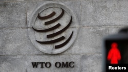 A logo is pictured outside the World Trade Organization (WTO) headquarters next to a stop sign, in Geneva, Switzerland.