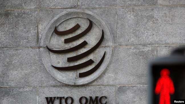 A logo is pictured outside the World Trade Organization (WTO) headquarters next to a stop sign, in Geneva, Switzerland.