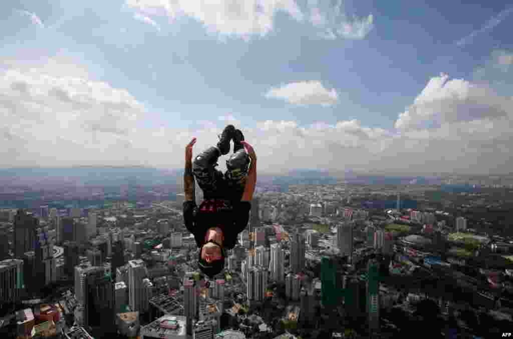 29 tháng 9: Tay nhào lộn Dan Smith của Úc có đeo dù phóng mình ra khỏi tòa tháp Kuala Lumpur. REUTERS/Bazuki Muhammad