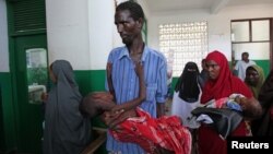 Internally displaced man carries cholera-stricken son through pediatric ward, Banadir hospital, Mogadishu, Aug. 25, 2011.