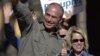 Bob Beauprez and wife Claudia gesture to supporters as they drive by at a honk and wave, Tuesday, Nov. 7, 2006, in Denver.