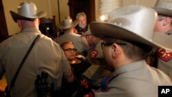 Police carry pro-choice advocate down stairs of the State Capitol, Austin, Texas, July 13, 2013.