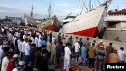 Muslims attend an Eid al-Fitr mass prayer to mark the end of the holy fasting month of Ramadan at Sunda Kelapa port in Jakarta, Indonesia, June 25, 2017.