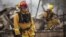 Firefighters search for victims in the rubble of a home burnt by the Valley Fire in Middletown, California, Sept. 14, 2015.