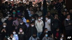 Decenas de personas algunas con mascarillas, visitan el Templo del Cielo en Beijing, 26 de febrero de 2023. 