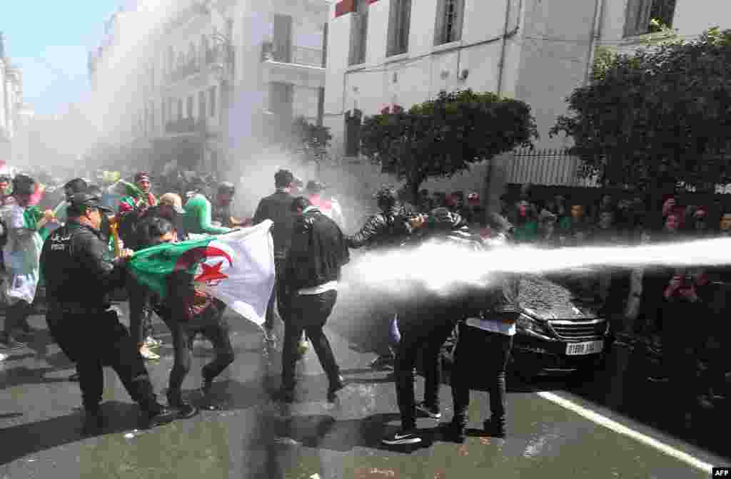 Algerian security forces use a water canon against students taking part in an anti-government demonstration in the capital, Algiers.