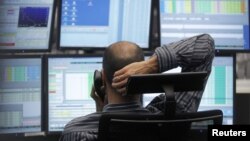 A trader makes a phone call at his desk at the Frankfurt stock exchange, July 24, 2012. 