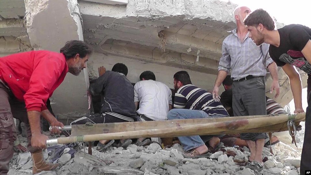This citizen journalism image shows Syrian citizens searching under rubble to rescue people from a building that was destroyed from a Syrian forces airstrike, at Kfar Nebel town, in Idlib province, northern Syria, October 17, 2012.