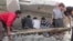 This citizen journalism image shows Syrian citizens searching under rubble to rescue people from a building that was destroyed from a Syrian forces airstrike, at Kfar Nebel town, in Idlib province, northern Syria, October 17, 2012.