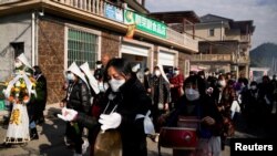 Kerabat dan tetangga menghadiri pemakaman seorang perempuan bermarga Liu, di tengah wabah COVID-19, di sebuah desa di Tonglu County, Provinsi Zhejiang, China, 9 Januari 2023. (Foto: REUTERS/Aly Song)